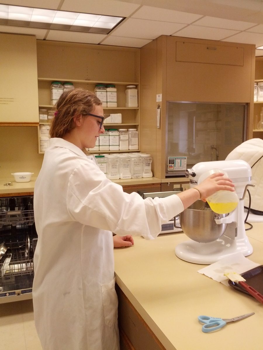 A food scientist adding liquid to a stand mixer during a bench-top trial